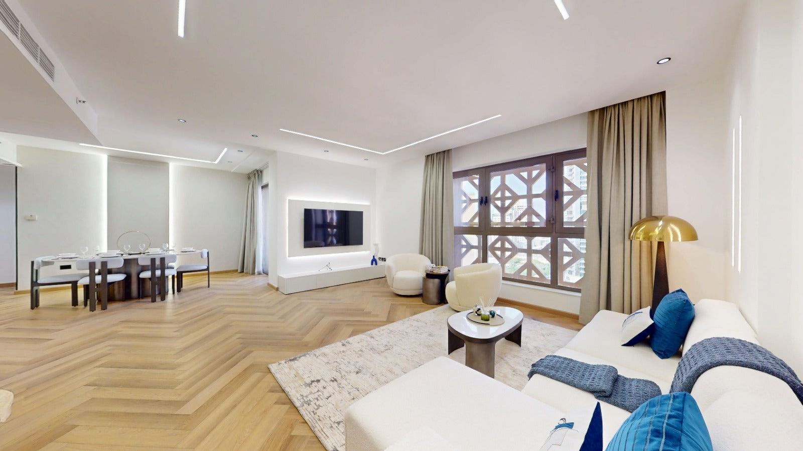 Modern living room with white furniture, a TV, and decorative elements.