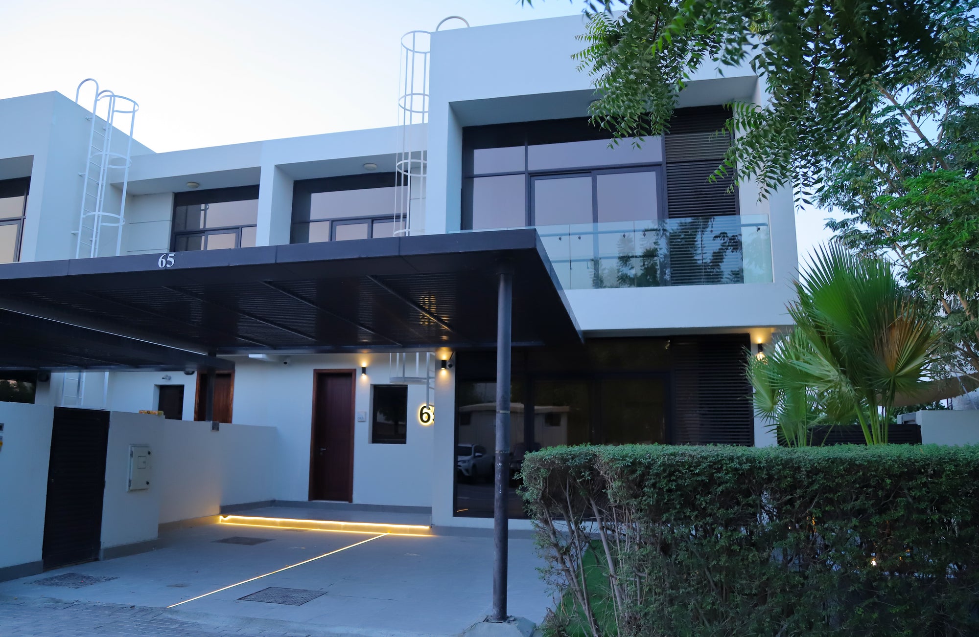 Modern building exterior with a driveway and greenery