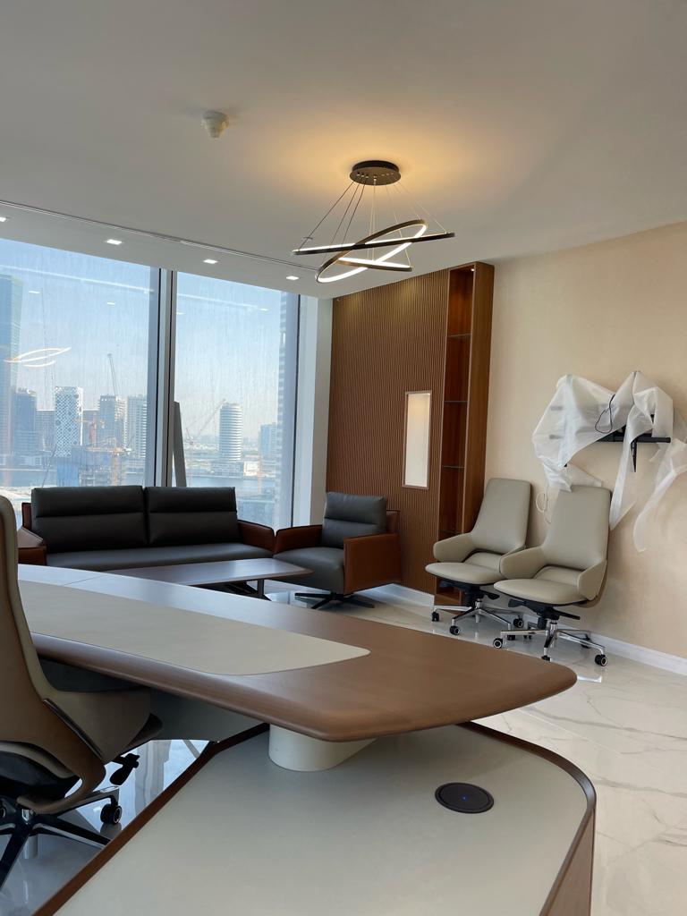 Modern office conference room with large window, sofa, and chairs.