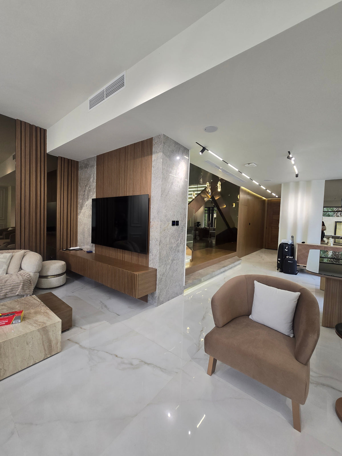 Modern interior with a kitchen island and chairs in a well-lit room.