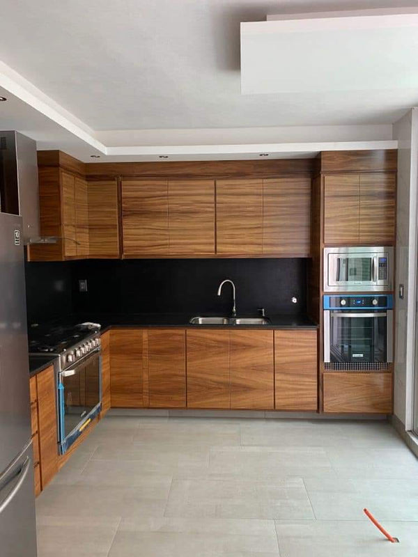 Modern kitchen with wooden cabinets, stainless steel appliances, and a black backsplash.
