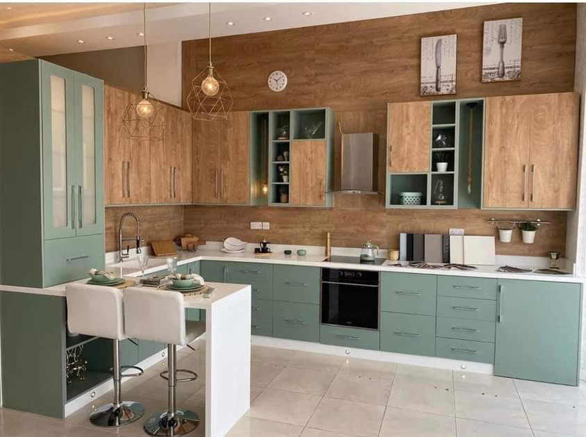 Modern kitchen with green cabinets and wooden walls