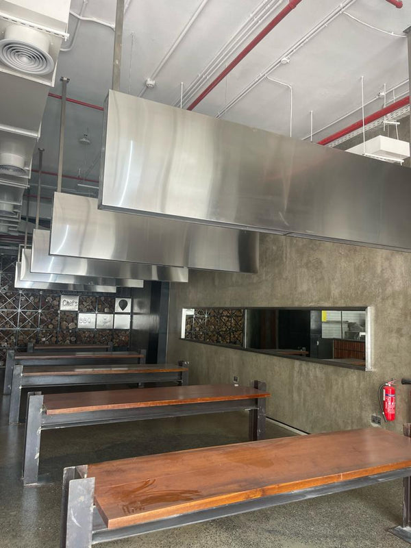 Commercial kitchen with stainless steel hood and wooden countertops