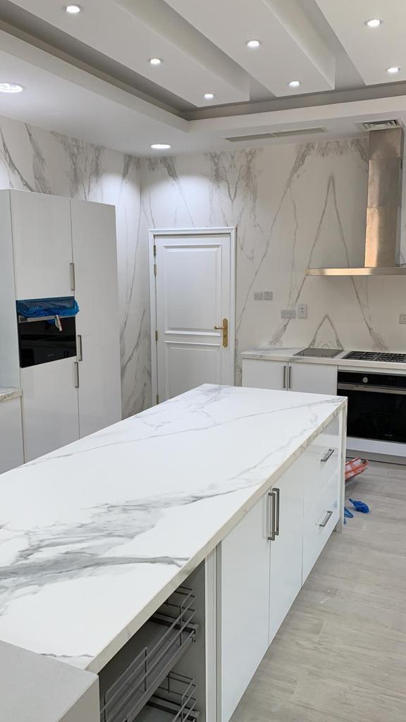 Modern kitchen with marble countertop and white cabinetry