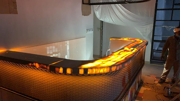 Modern indoor pool with curved edge and glowing lights, person standing nearby.